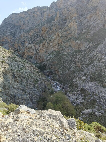 A rugged mountainous landscape with a rocky stream flowing through a canyon. 2
