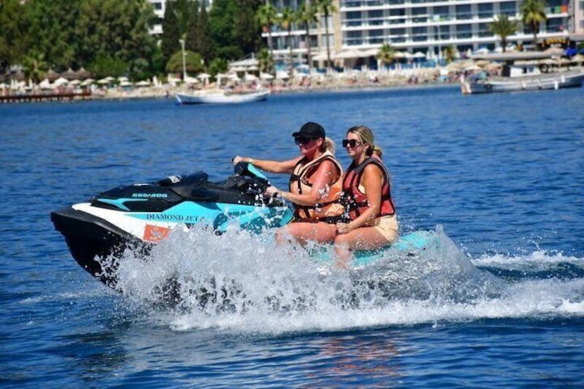 Dos personas en un jet ski con agua salpicando a su alrededor. 2