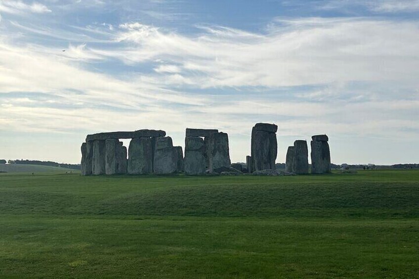 Stonehenge standing in a grassy field under a partly cloudy sky. 3