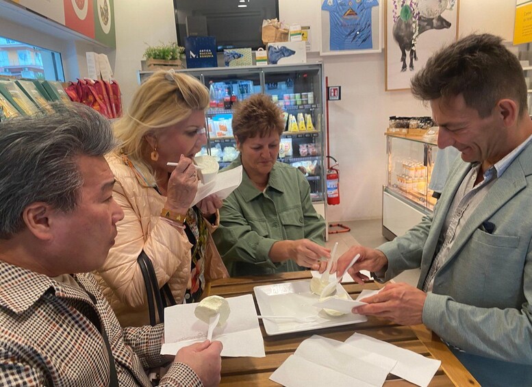 A group of people at a food tasting event, sampling various dishes. 2