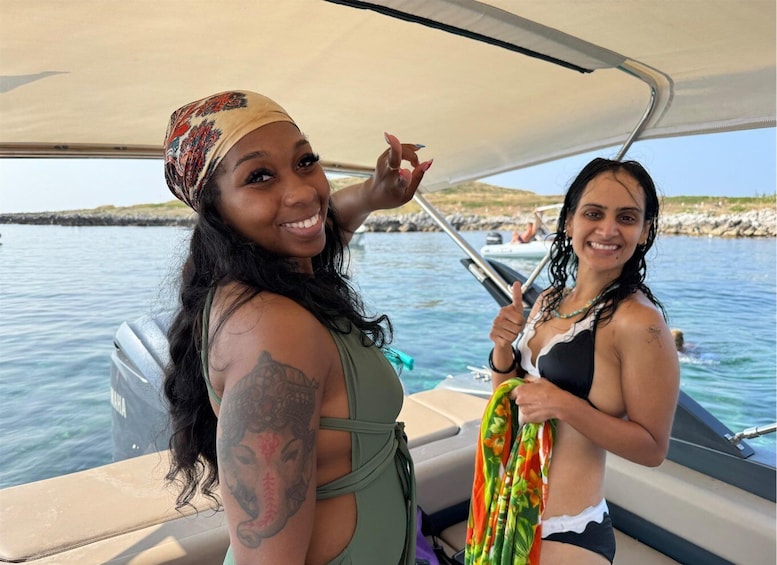 Two people on a boat with a rocky shoreline in the background. 2
