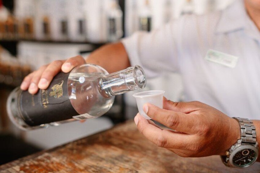 Una persona sirviendo una bebida de una botella en una taza. 5
