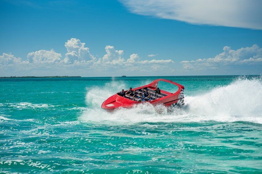 Un bateau à moteur rouge sur une eau turquoise, sous un ciel dégagé. 2