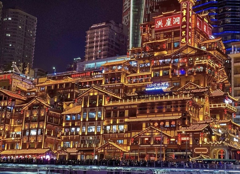 A traditional Chinese building with illuminated signage and architecture, surrounded by modern high-rise buildings. 5