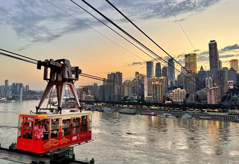 A cable car over a river with a city skyline in the background. 3