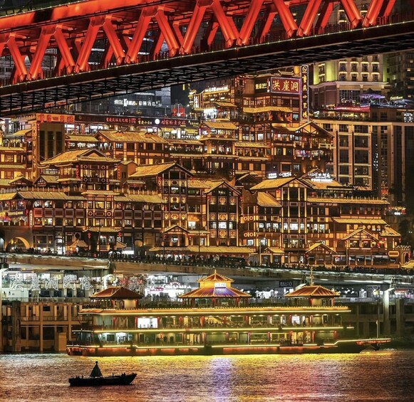 A river with traditional buildings and a red bridge in the background. 2