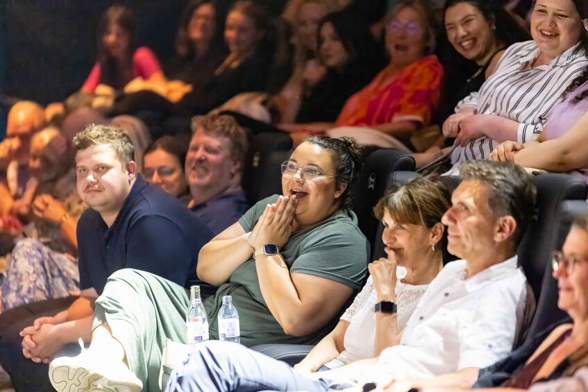 An indoor auditorium with people seated in rows. 2