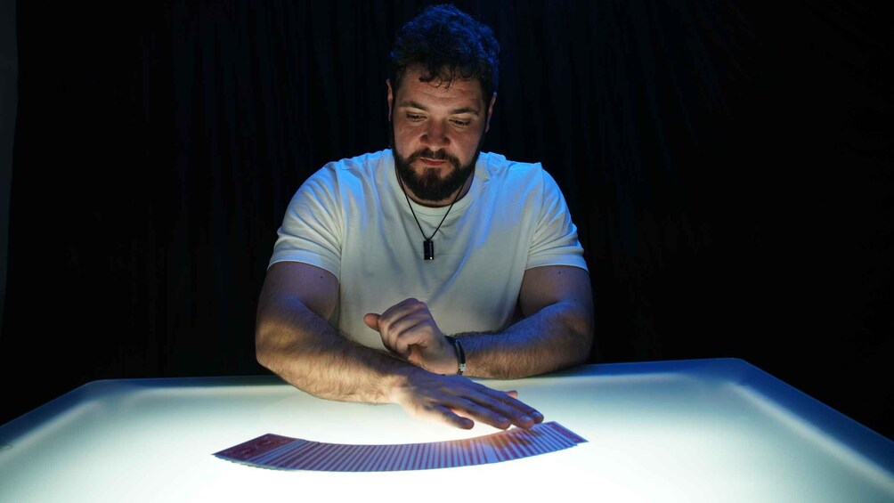 A person sitting at a table with cards. 4
