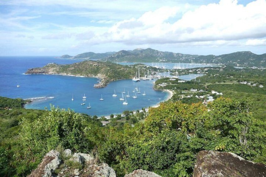 A coastal landscape with a bay, sailboats, and a distant bridge. 1