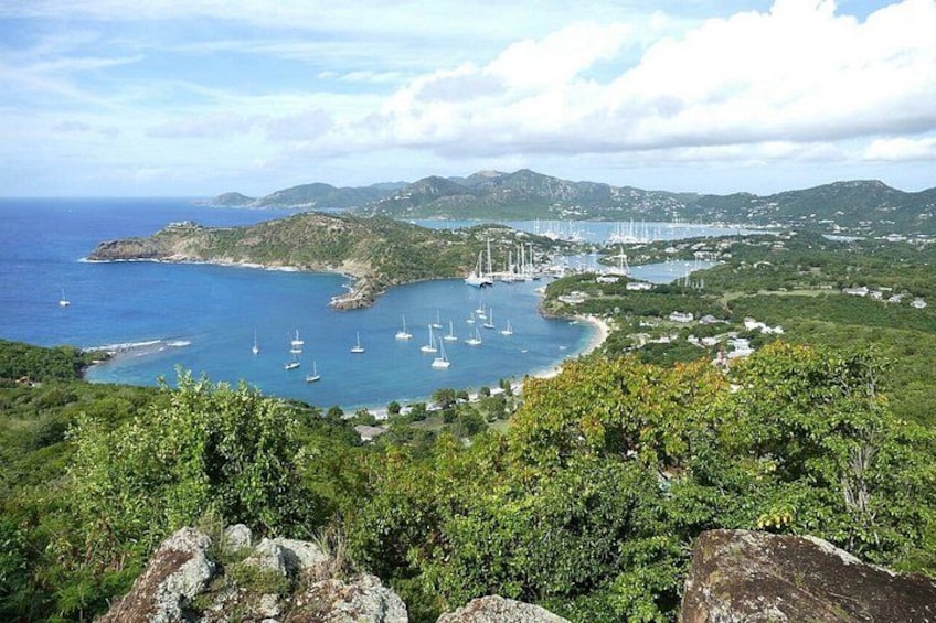 A coastal landscape with a bay, sailboats, and a hilly backdrop. 1