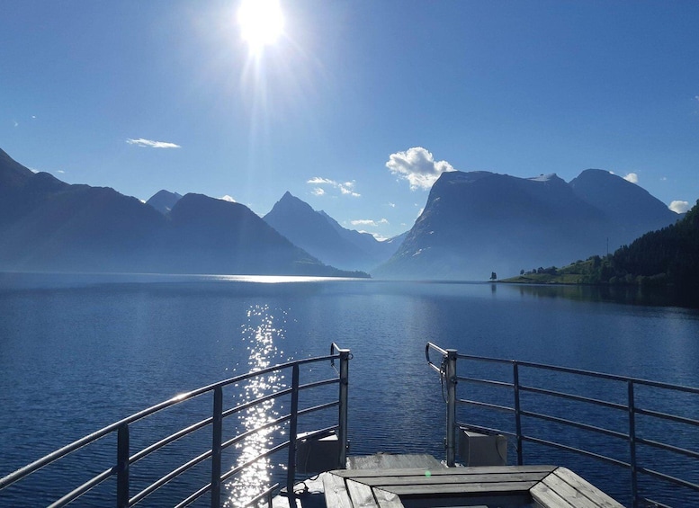 A calm lake with mountains in the background and a wooden dock in the foreground. 5