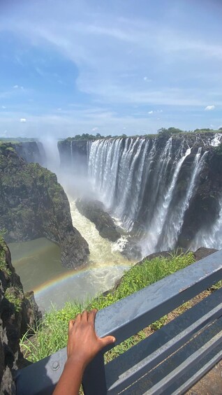 A large waterfall with a rainbow at its base, viewed from a high vantage point. 5