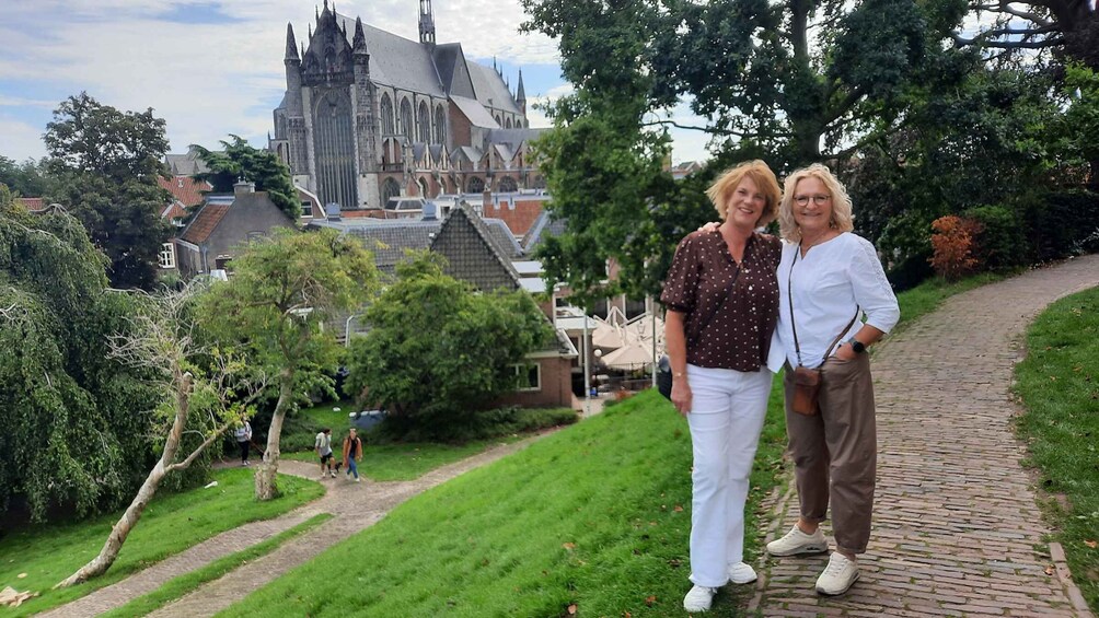 Two people standing on a brick path with a historic church in the background. 2