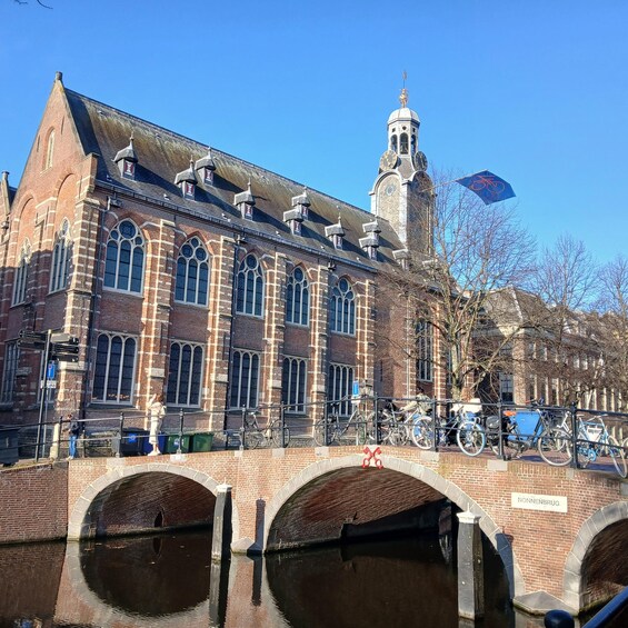 A historic building with a clock tower, a bridge, and a canal. 5