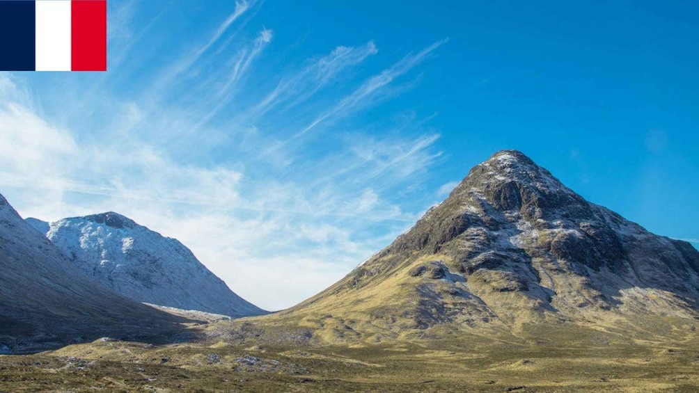 A mountain landscape with clear skies and a flag in the upper left corner. 3