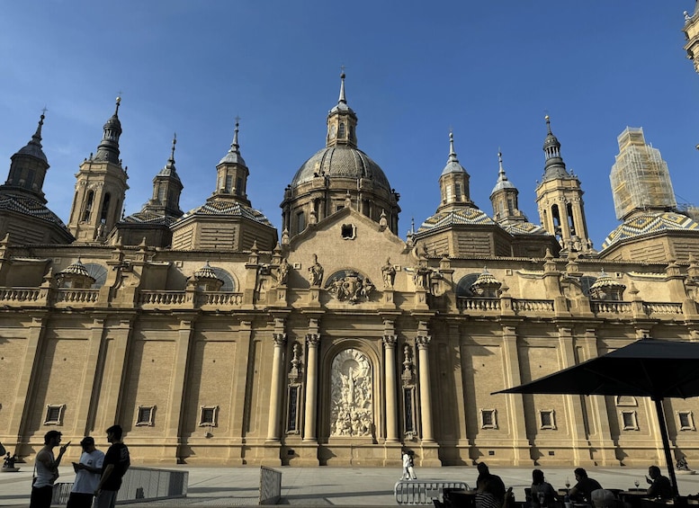 A historic building with multiple domes and a central statue. 2