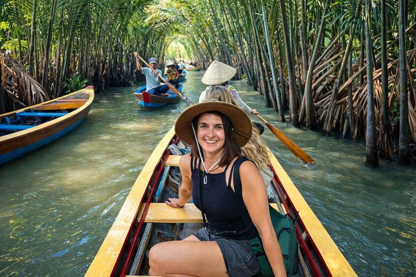 A person in a boat on a waterway surrounded by tall, narrow trees. 1