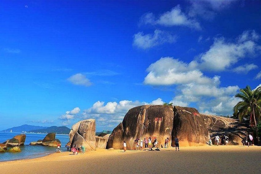 Une plage avec de grandes formations rocheuses, des palmiers et des gens. 2