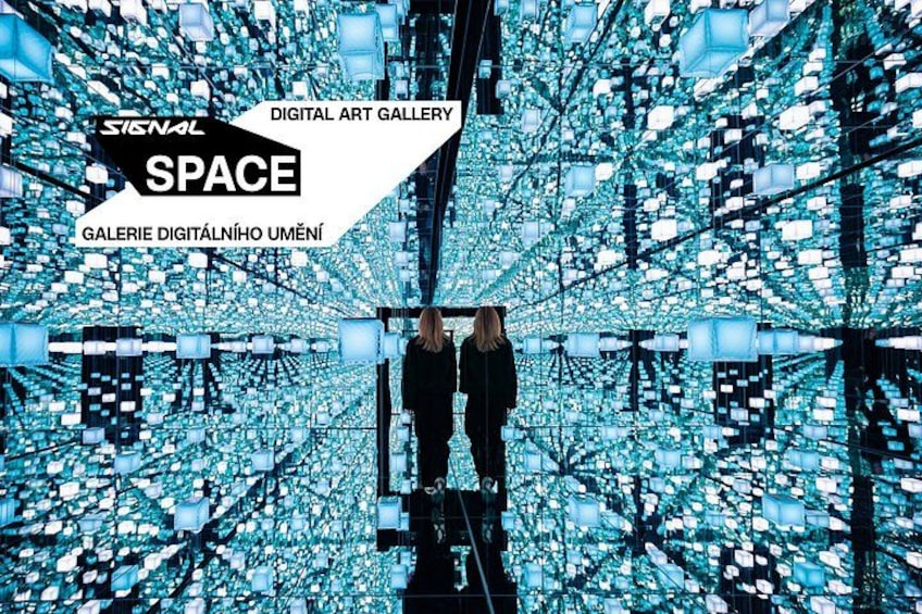 A digital art gallery with a person standing in front of a reflective, geometric light installation. 1
