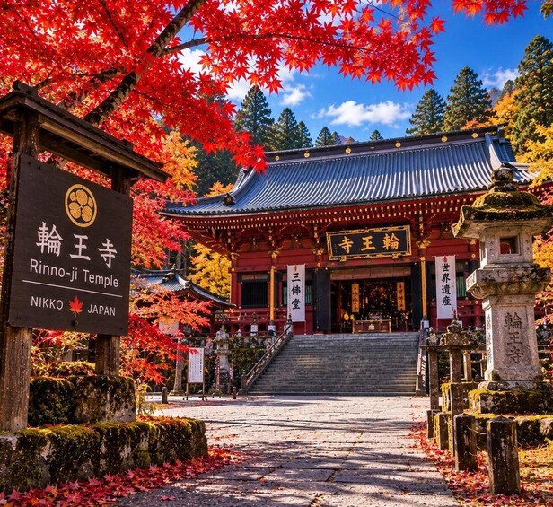 The Rinnō-ji Temple entrance with traditional Japanese architecture, autumn foliage, and a clear sky. 2