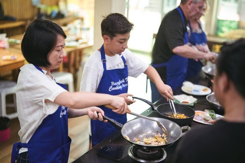 Des personnes cuisinent dans une cuisine, portant des tabliers. 1