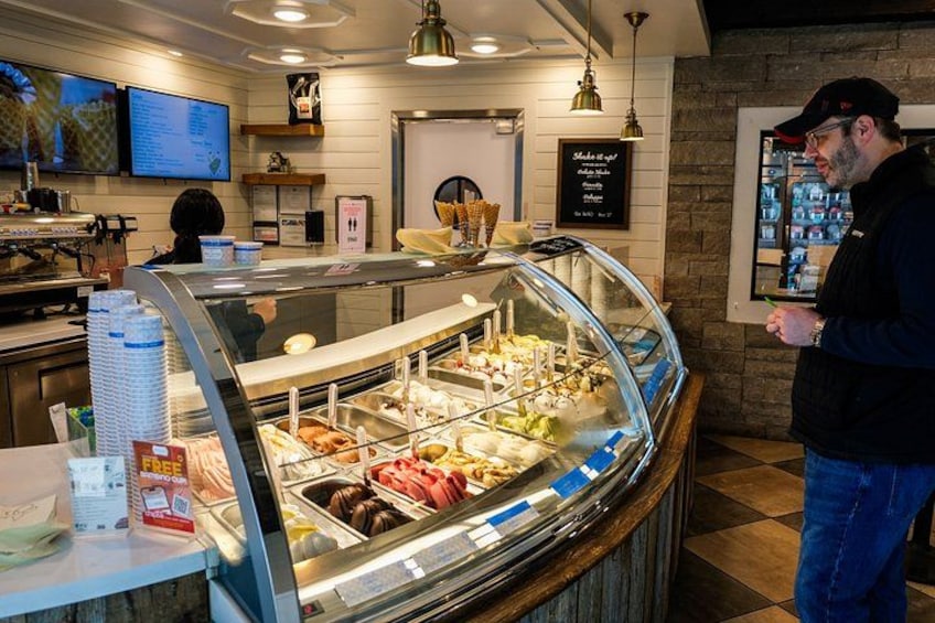A bakery counter with various pastries and a menu board. 3