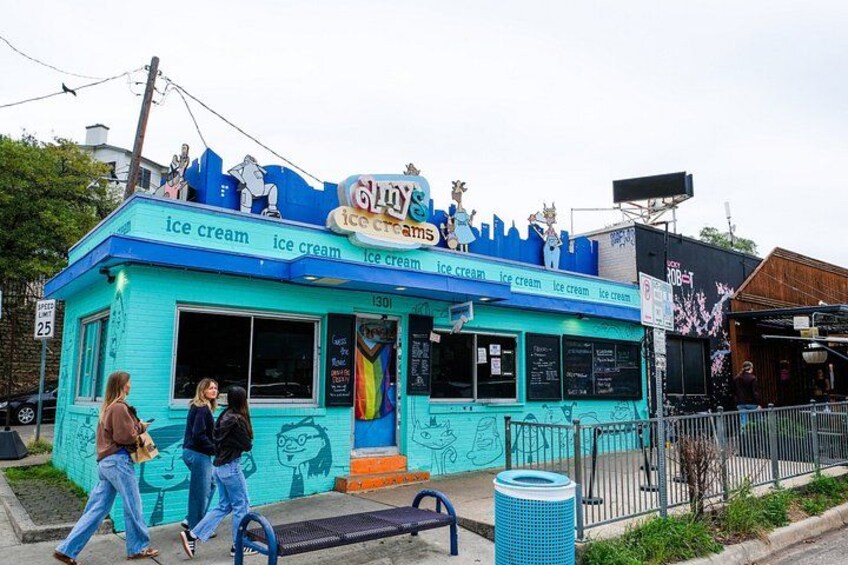 A turquoise ice cream shop with cartoon characters on the roof and a sign that reads 'Gulfs Ice Cream.' 4