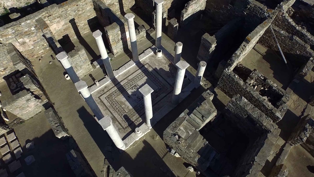 An aerial view of ancient ruins with columns and stone structures. 5