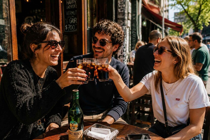 Three people toasting with drinks at an outdoor cafe. 4