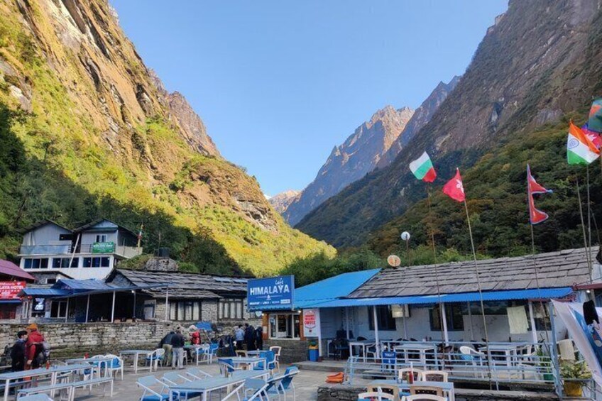 A mountainous village with a blue-roofed building labeled 'HIMALAYA' and several flags. 5