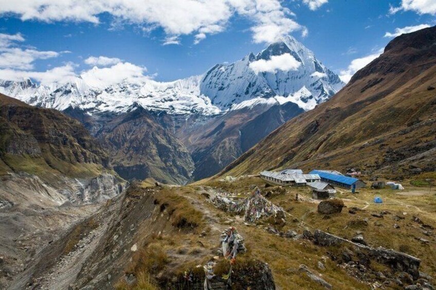 A mountainous landscape with a snow-capped peak, a small building, and a valley. 4
