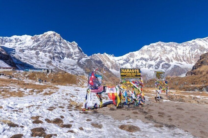 A snowy mountain landscape with a colorful prayer flag installation and a sign reading 'NAMASTE.' 3