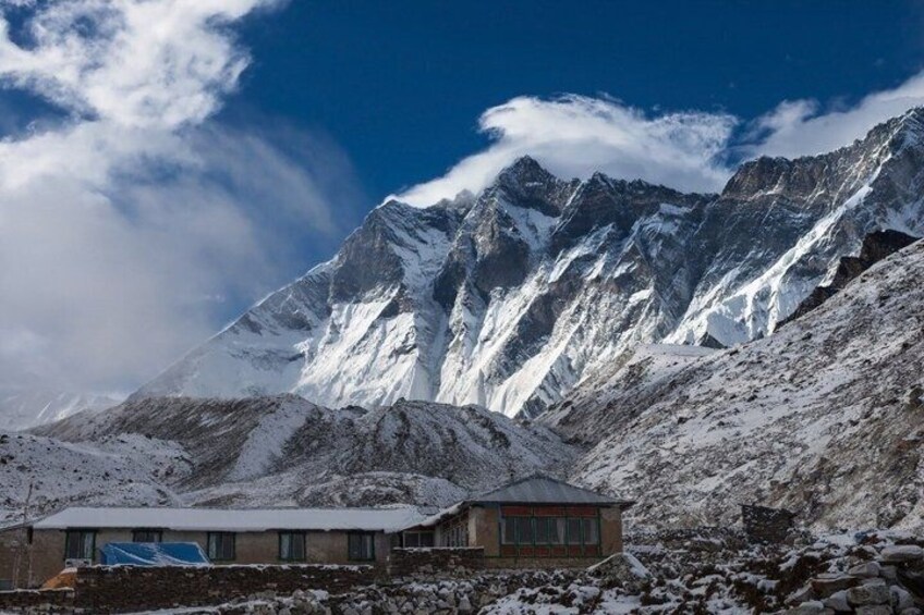 A snow-covered mountain with a small building in the foreground. 2