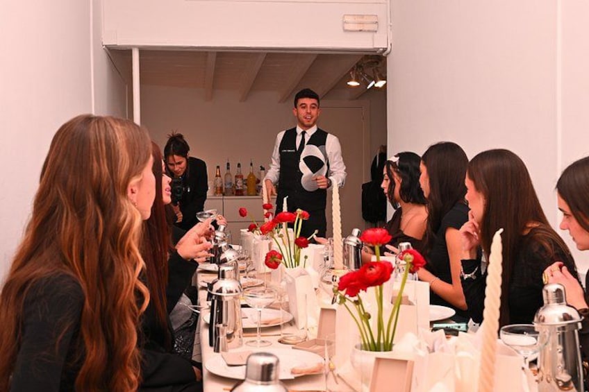 Un gruppo di persone sta cenando in un ristorante mentre un cameriere si occupa di loro. 1