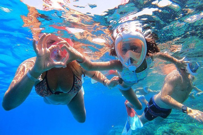Due persone fanno snorkeling sott'acqua in acque cristalline tra le rocce. 4