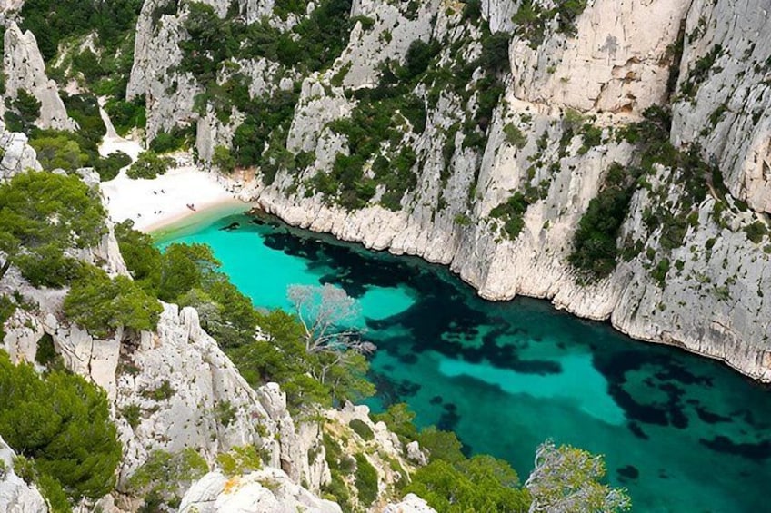 A coastal landscape with cliffs, a beach, and turquoise waters. 5