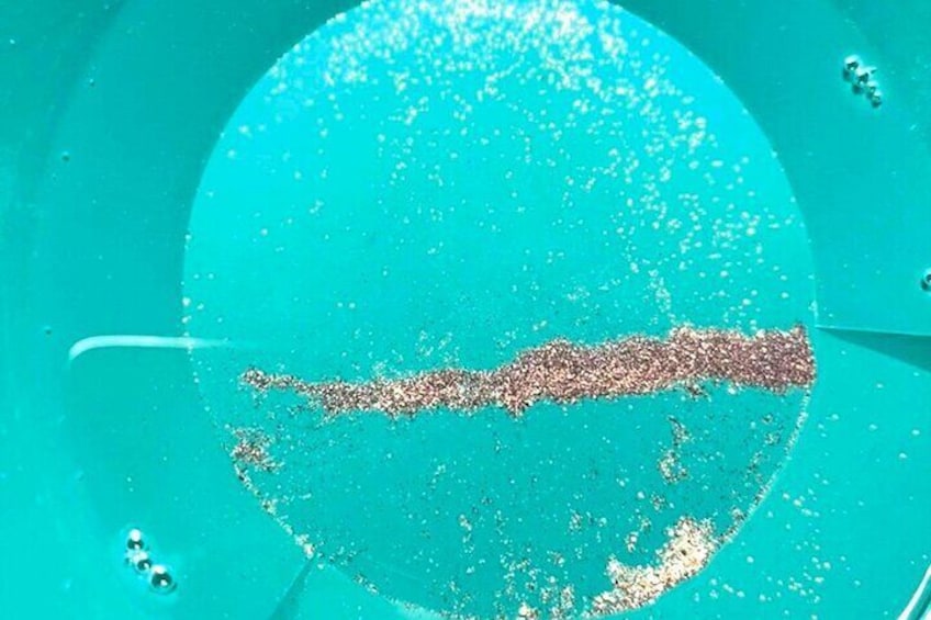 A turquoise circular object with a textured surface and a central line. 3