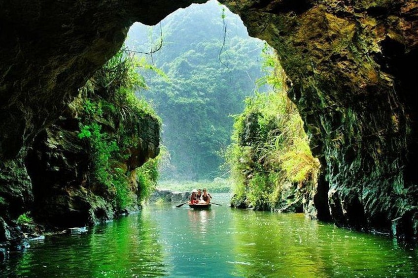 A river through a cave with people in a boat. 1
