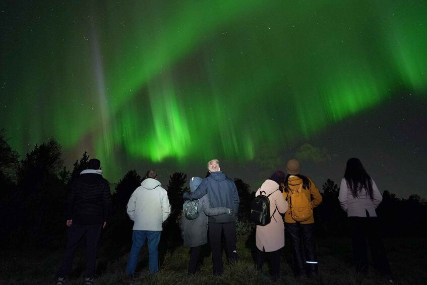 Un grupo de personas observando las auroras boreales. 5