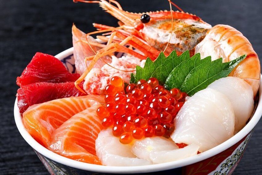 Een schaal met sashimi van garnaal, zalm en roeien. 5