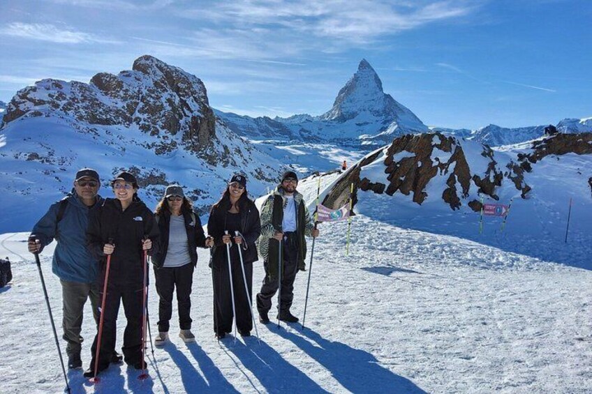 Een groep mensen skiënd op een besneeuwde berg met een opvallende piek in de verte. 1