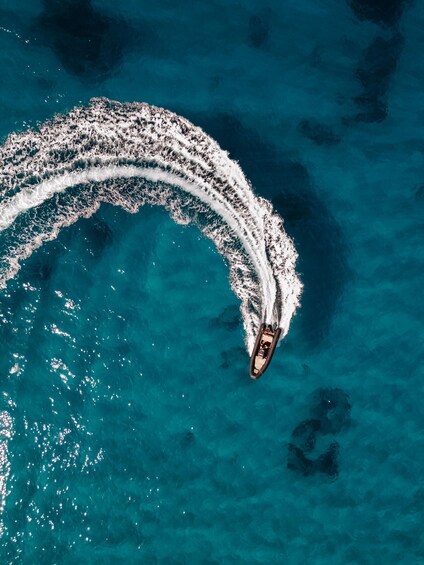 A boat creating a wake in turquoise waters. 1