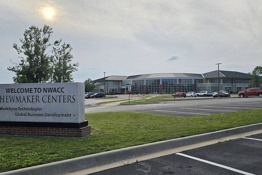 A sign for NWACC Heawmaker Centers, a building, and a parking lot. 3