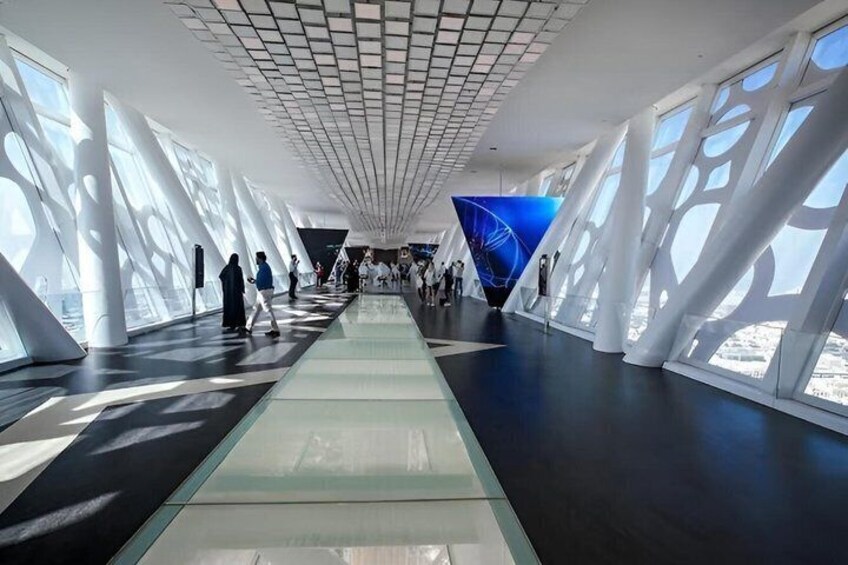 A modern building with a glass facade, a central walkway, and a geometric ceiling design. 4
