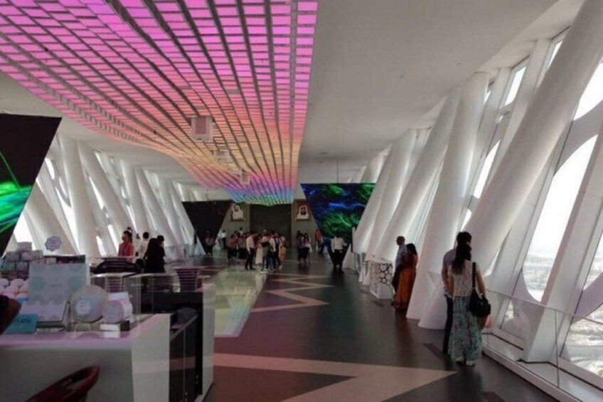 A modern interior with a unique ceiling design, large windows, and a central walkway. 5