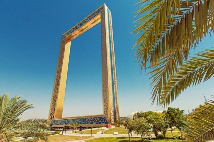 A tall, ornate archway with intricate patterns, surrounded by palm trees and a clear blue sky. 2