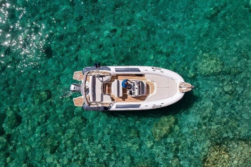 A small motorboat on clear turquoise water. 1