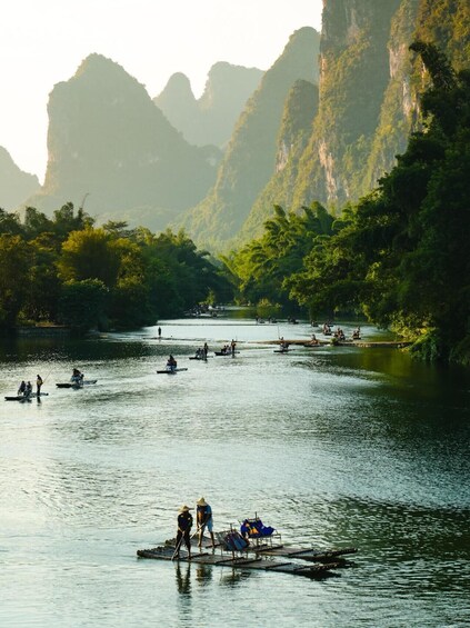 A river with people on boats and a dock with people standing. 5