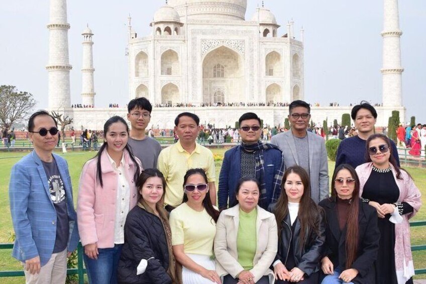 En gruppe mennesker poserer foran Taj Mahal. 4