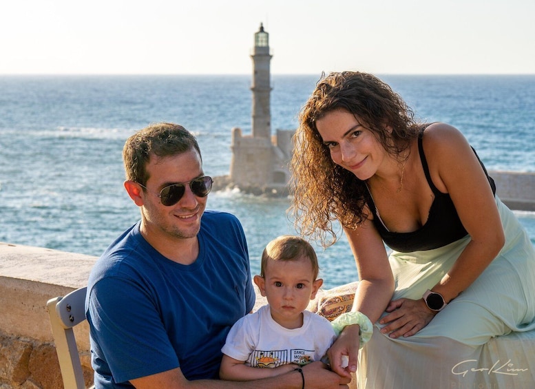 A family by a coastal area with a lighthouse in the background. 1